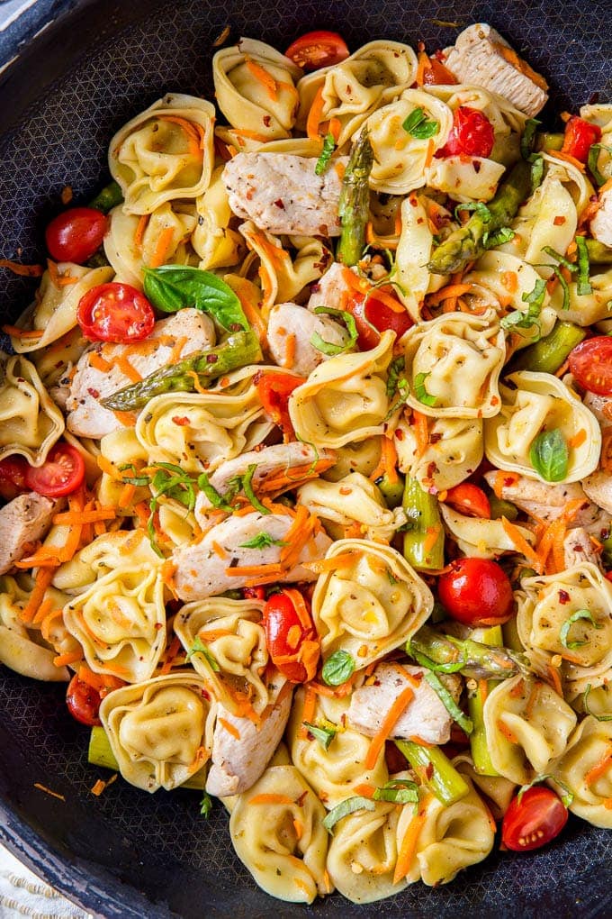 Tortellini, chicken and vegetables in a large skillet to make tortellini salad.