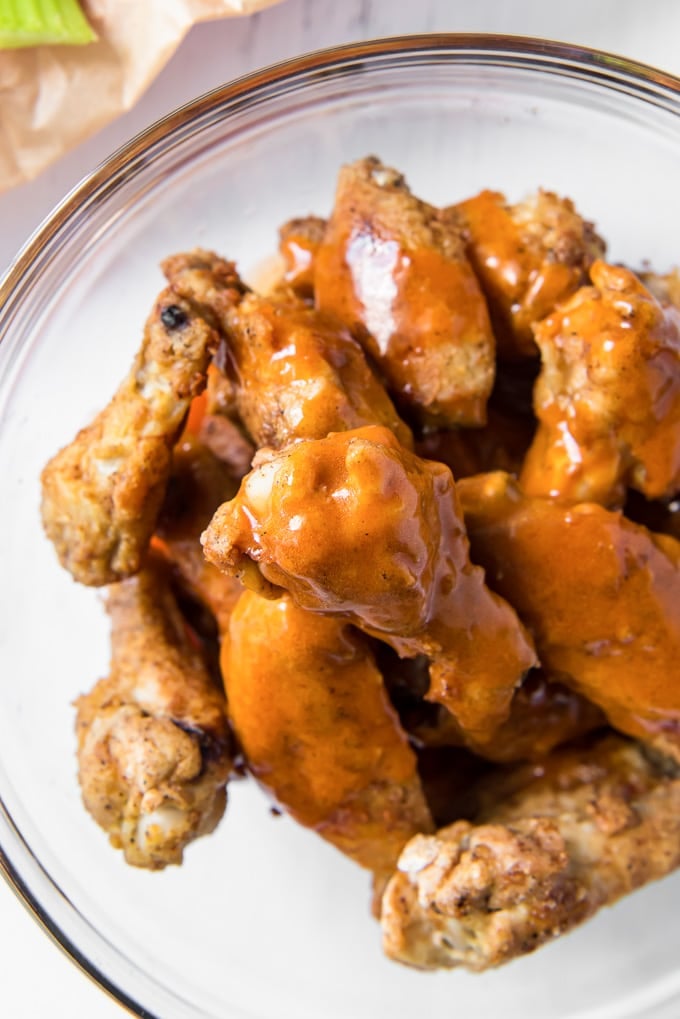 chicken wings in a bowl with buffalo sauce