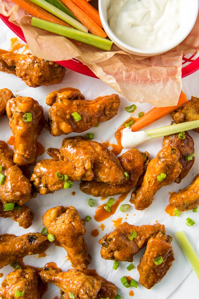 buffalo chicken wings on a large baking sheet with carrots and celery and ranch