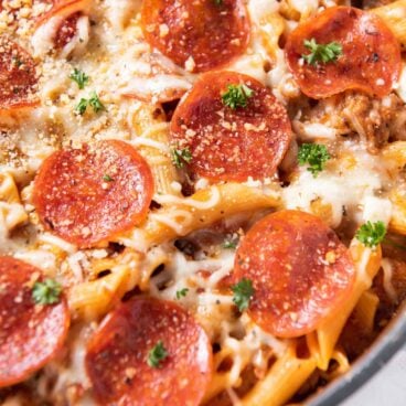 pepperoni, pasta, sauce in a large pot with parsley garnish.