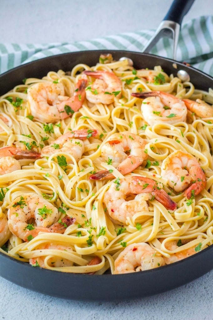 shrimp scampi in a skillet with pasta