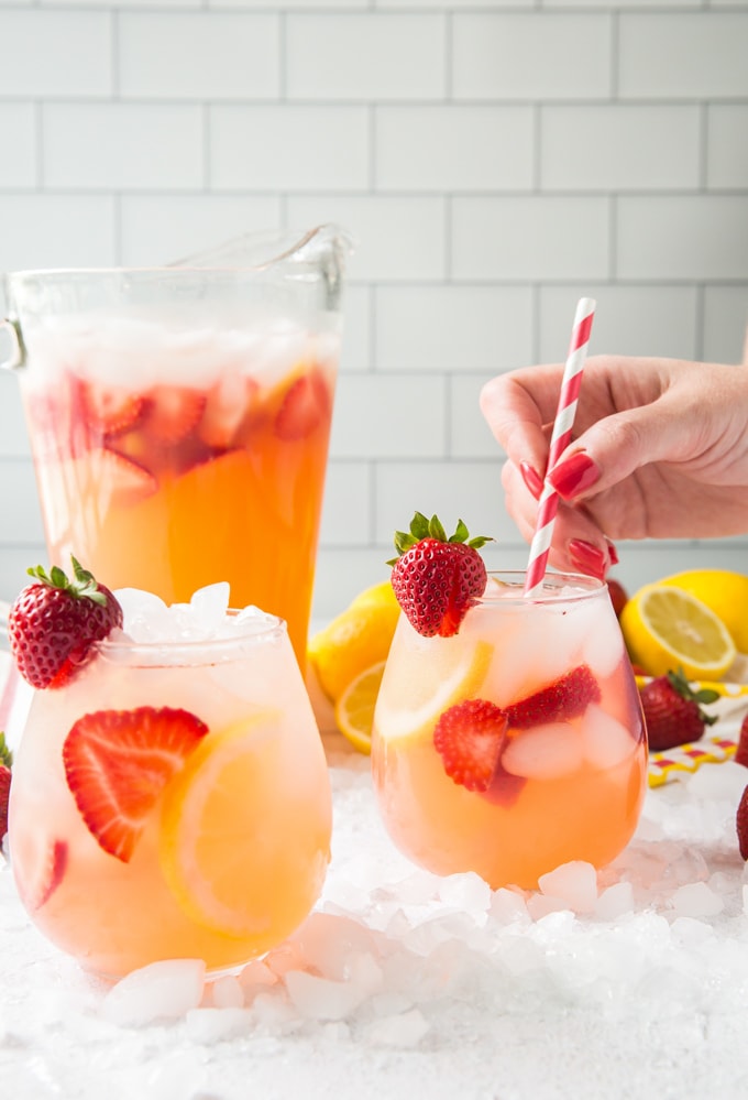 Strawberry Lemonade in a pitcher and in glasses with fresh fruit.