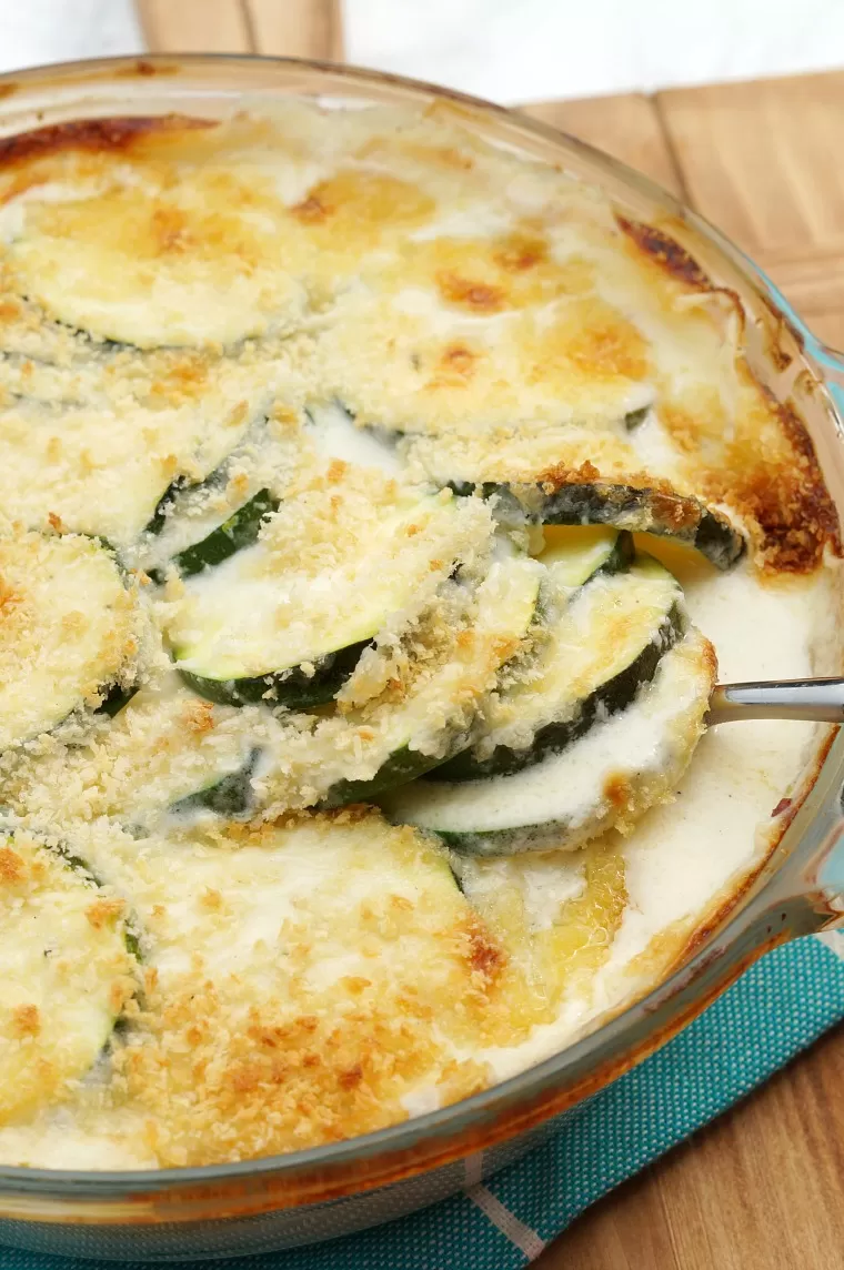 A zucchini casserole with a spoon pulling out a serving.