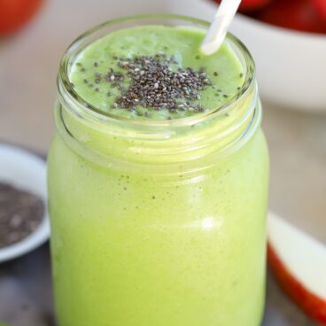 A green smoothie topped with chia seeds in a mason jar.