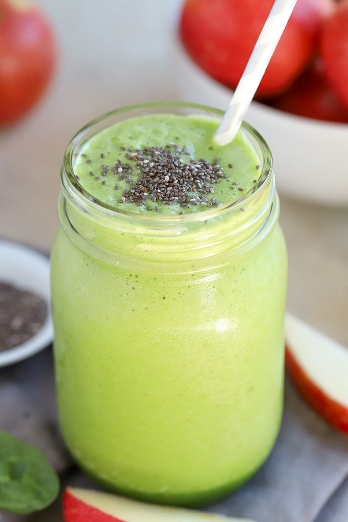 A green apple smoothie topped with chia seeds in a mason jar.