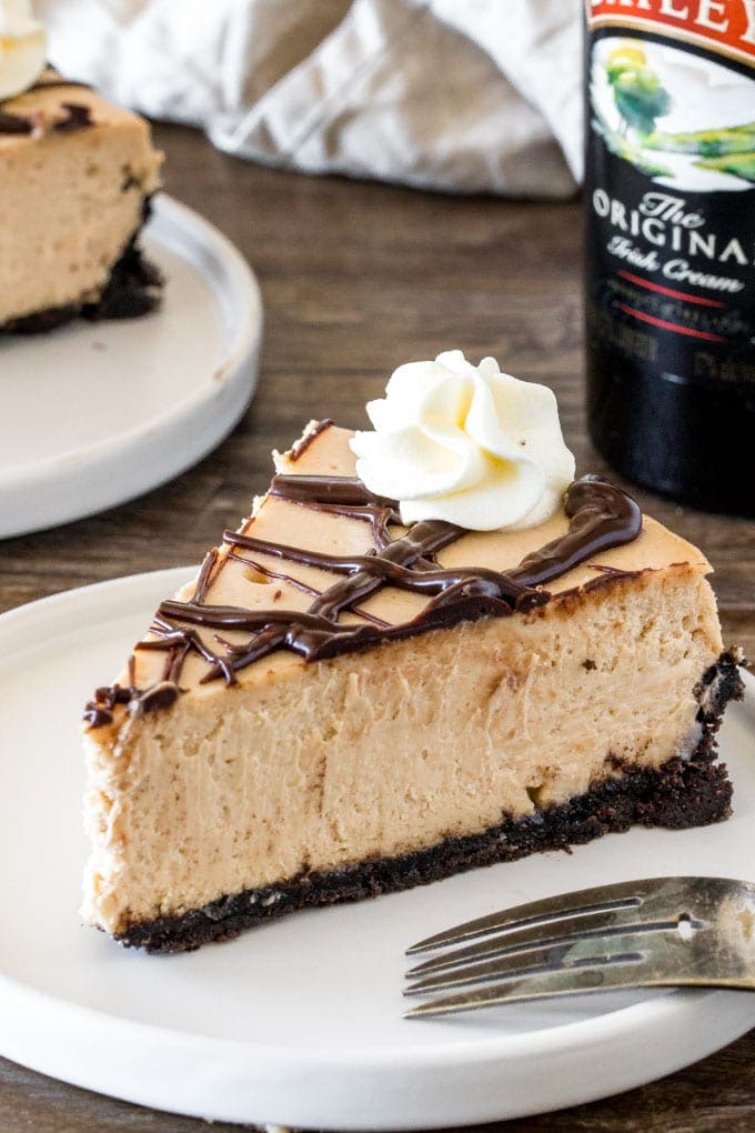 A slice of extra creamy Baileys cheesecake with an Oreo crust and chocolate ganache. 