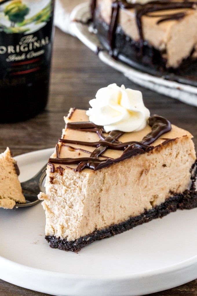 A slice of Irish cream cheesecake with a bite take out of it to show the creamy texture. 