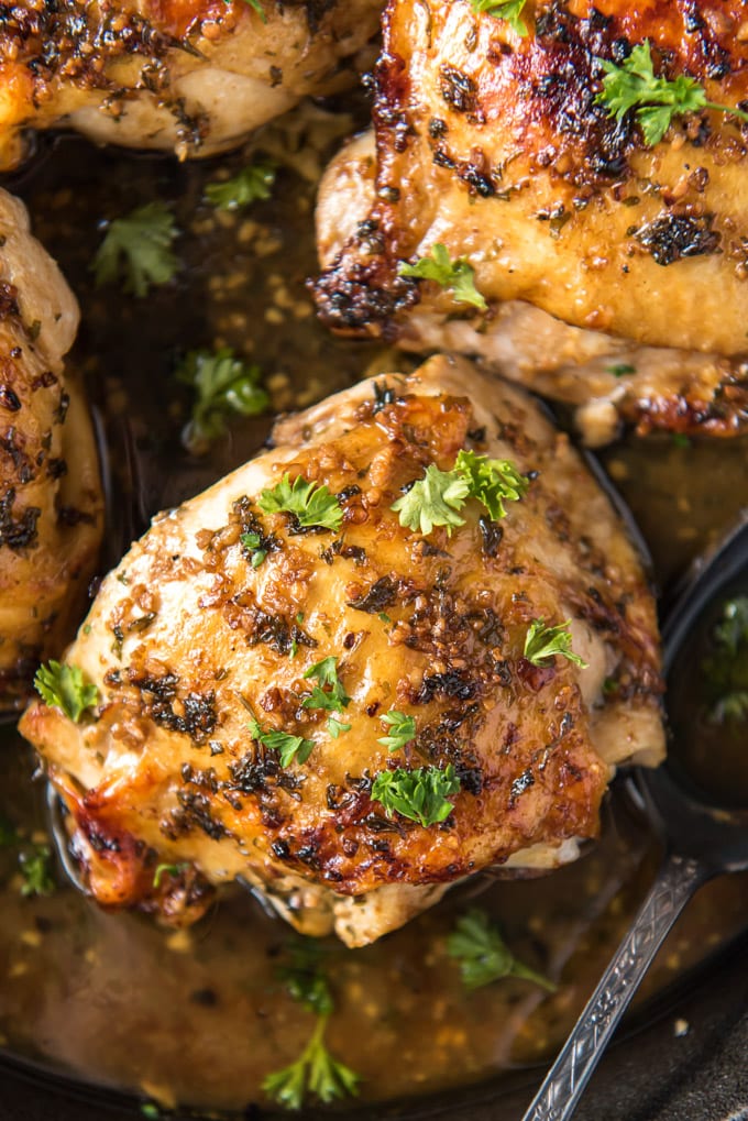 close up of roasted chicken thighs in cast iron skillet
