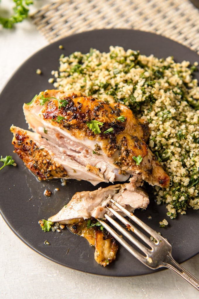 A plate of food with a fork, with Chicken Thighs, quionoa