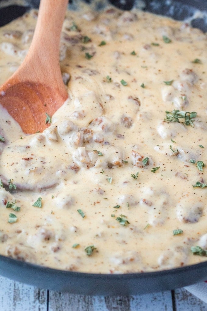 sausage gravy in a skillet with sage sprinkled on top