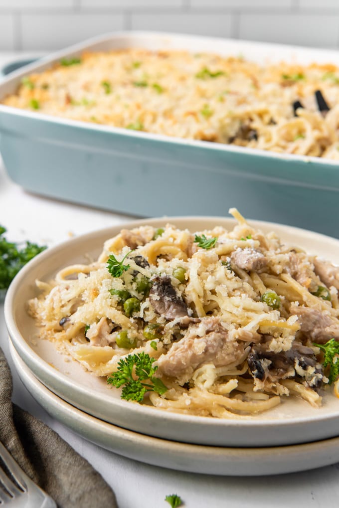 Turkey tetrazzini pasta with vegetables with a serving on a plate and the rest ina casserole dish