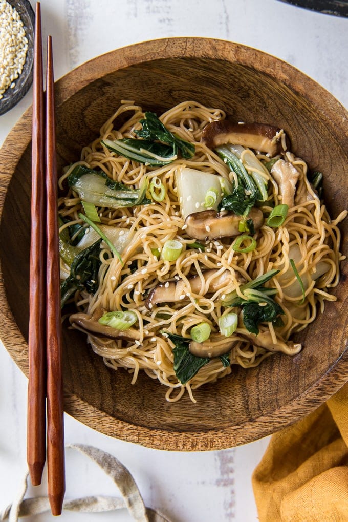 A bowl of vegetable chow mein with chopsticks