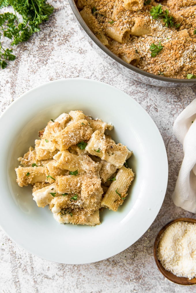 A white bowl filled with cheesy rigatoni