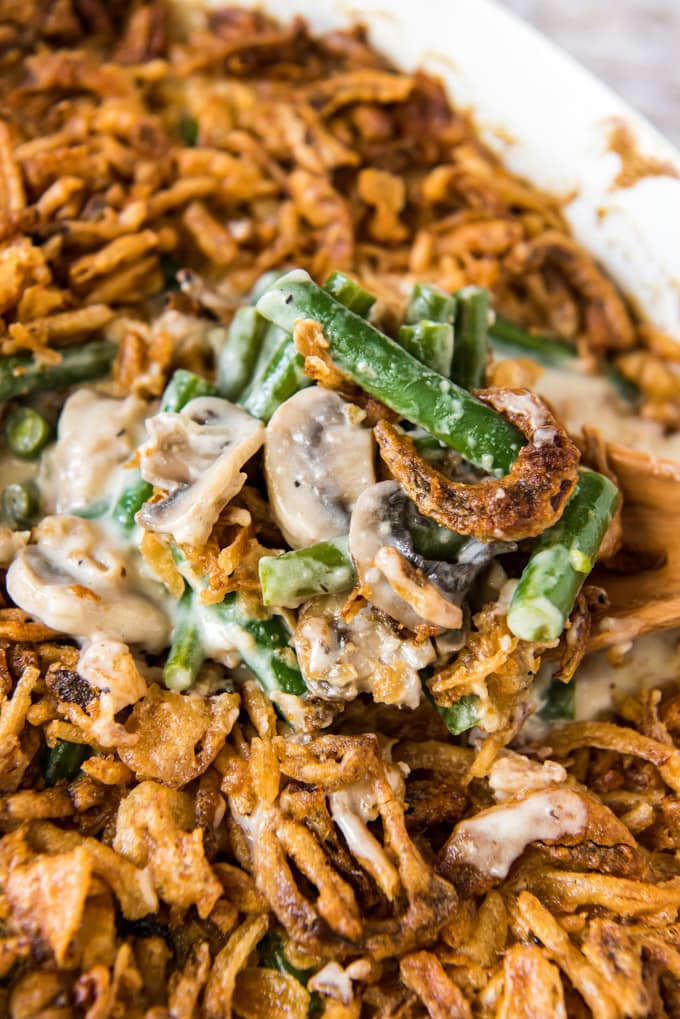 A side angle shot of a scoop of green bean casserole sitting on top of the casserole dish