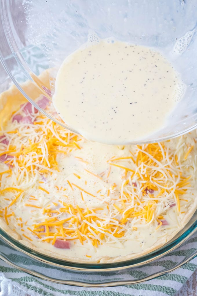 Ham and Cheese Quiche recipe is my go-to for brunch or holiday breakfast with the family. Incredibly easy to make and always a hit at breakfast! egg filling being pour over cheese and ham to make quiche