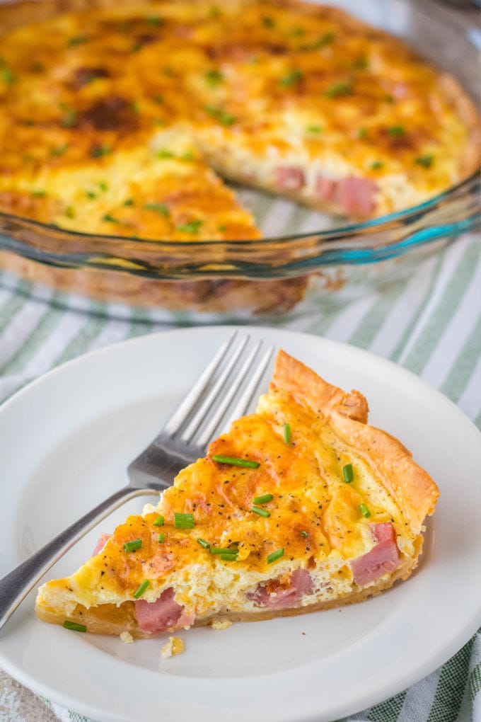 slice of Ham and Cheese Quiche on a plate with a fork