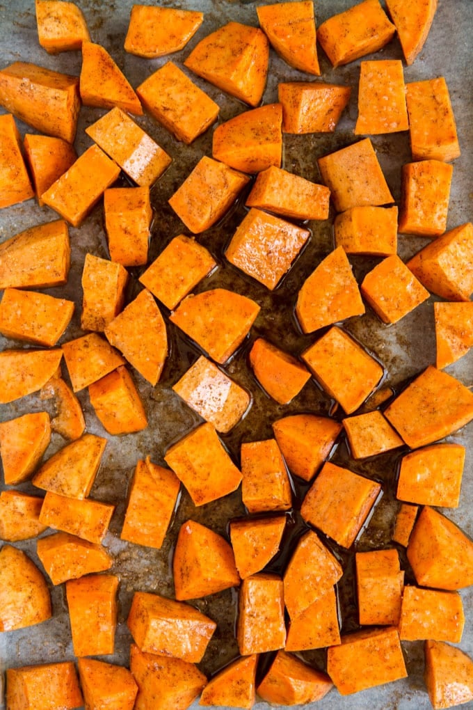 Cut up chunks of sweet potatoes on a sheet pan