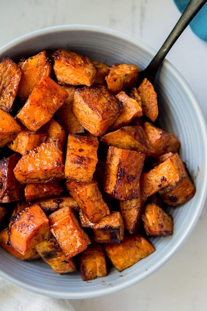 A bowl of roasted sweet potatoes with cinnamon and honey