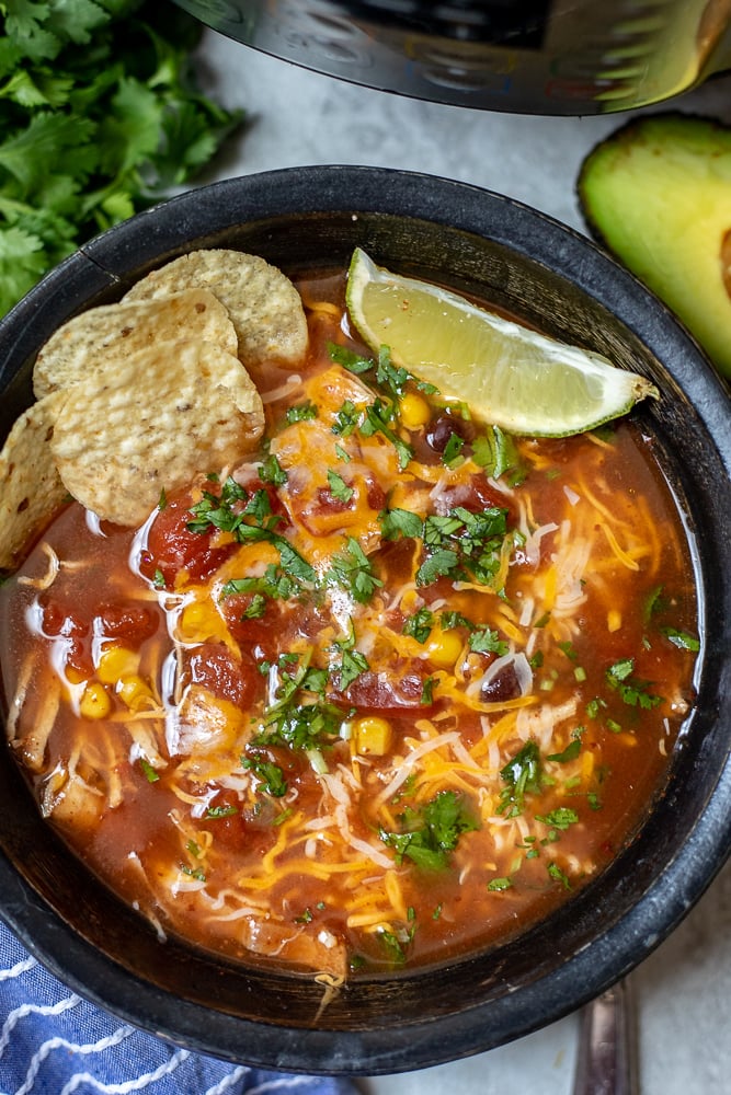 Close up of Instant Pot Chicken Tortilla Soup with lime and avocados