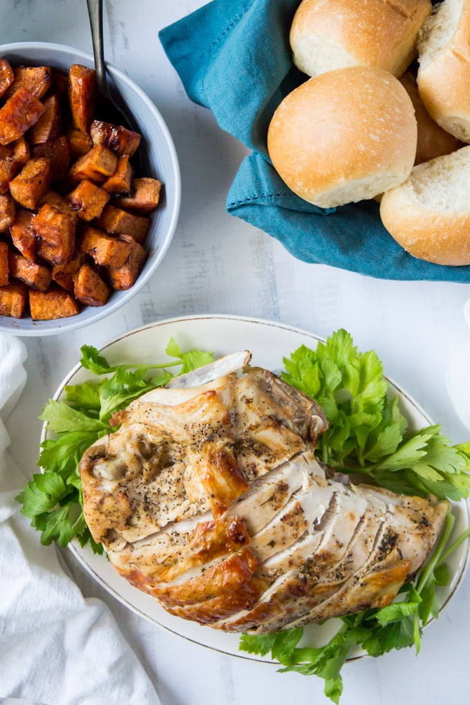 Sliced turkey breast cooked in the instant pot lying on a plate with parsley