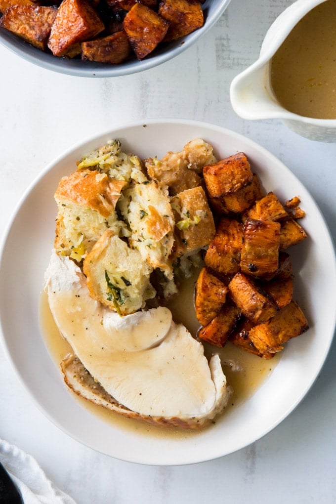 An overhead shot of a thanksgiving plate with turkey ,stuffing and sweet potatoes