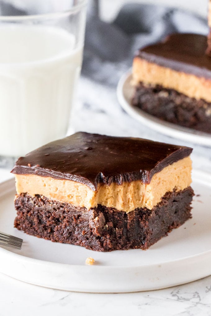 A layered peanut butter brownie with a bite taken out of it. 