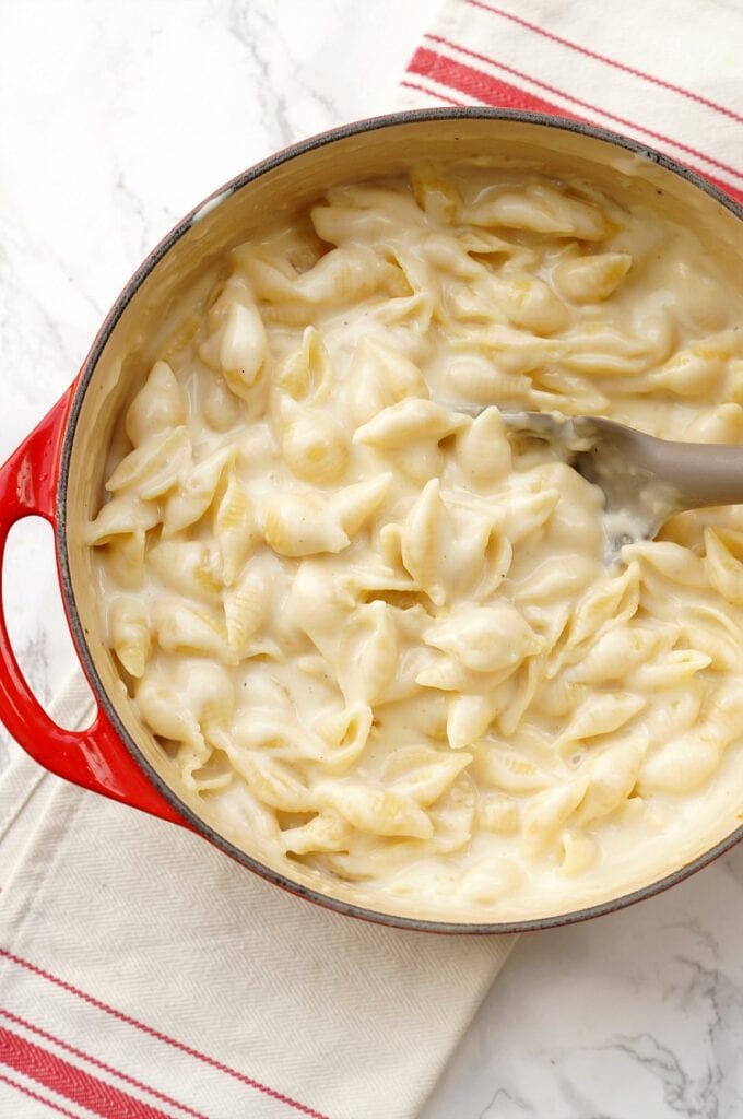 panera copycat mac and cheese in a red pot with a wooden spoon