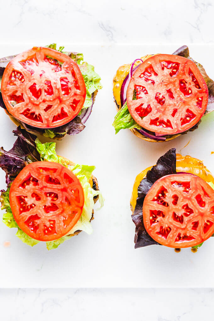 Overhead shot of four turkey burgers on cutting board.