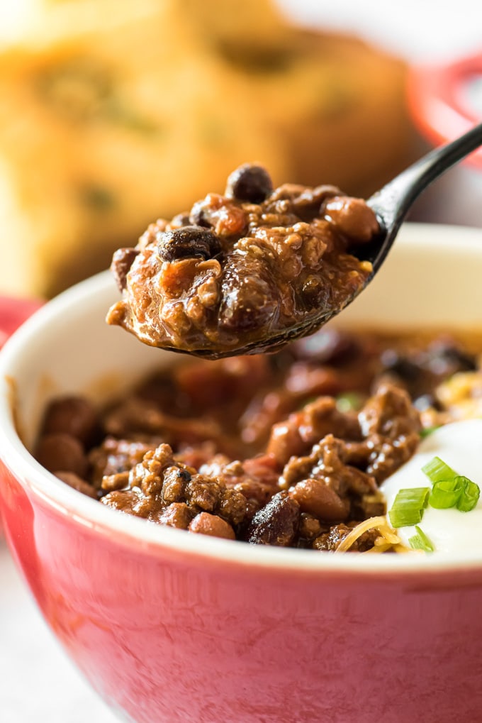 A spoonful of chili over a bowl