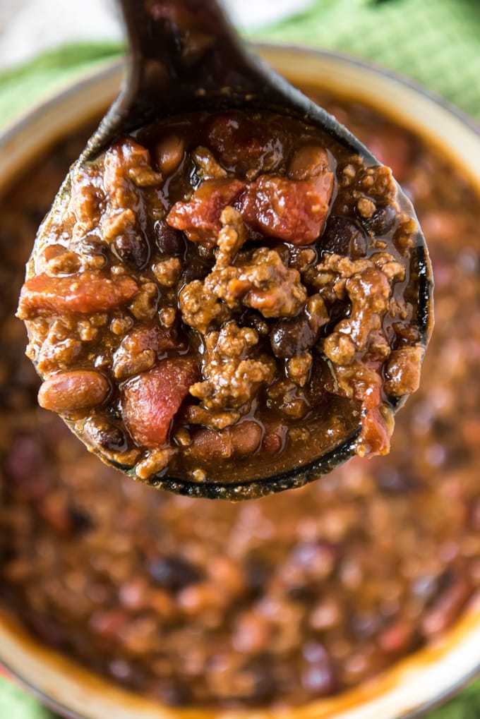 A ladle of chili over a pot