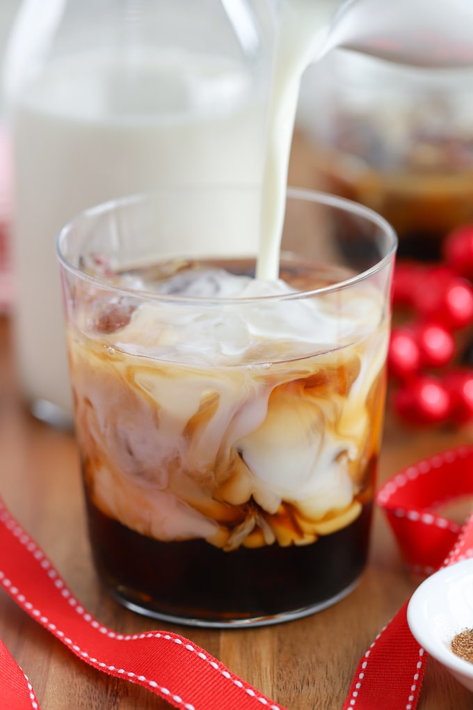 Eggnog being poured into a white russian cocktail.