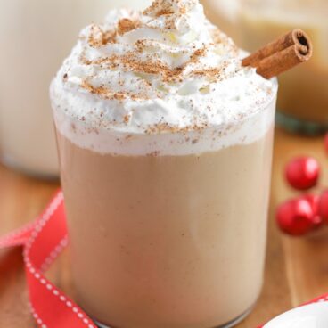 Eggnog White Russian Cocktail topped with whipped cream and a cinnamon stick.