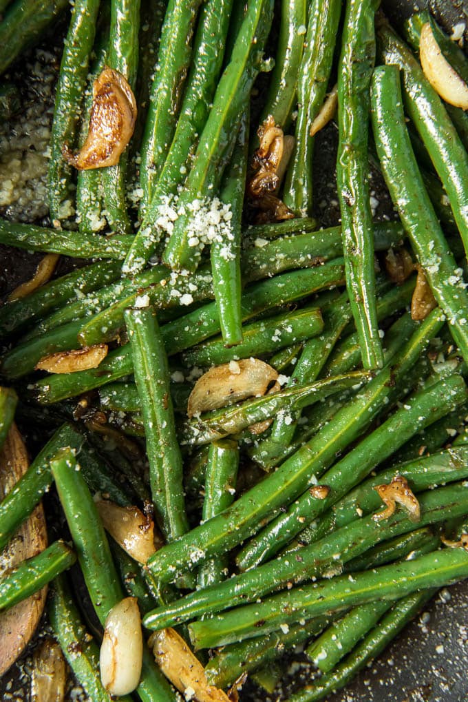 A close up overhead shot of green beans with garlic and parmesan