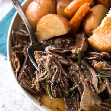 A bowl of pot roast with potatoes and carrots