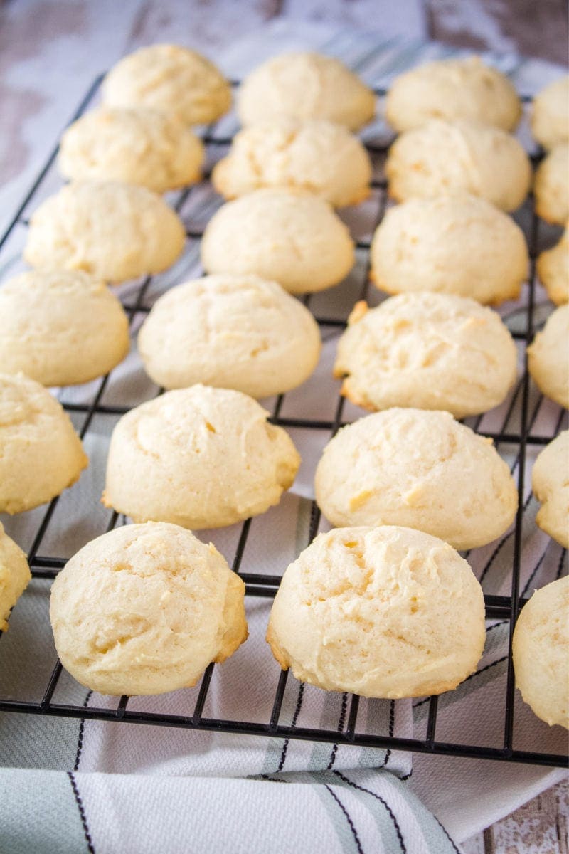 Italian Ricotta Cookies are a fluffy treat that begs to be eaten! Top them with your favorite seasonal sprinkles for an irresistible cookie perfect for the holidays! ricotta cookies on a cooling rack after baking