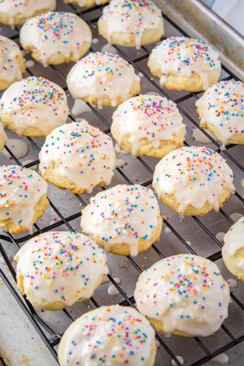 ricotta cookies on a cooling rack with glaze and sprinkles