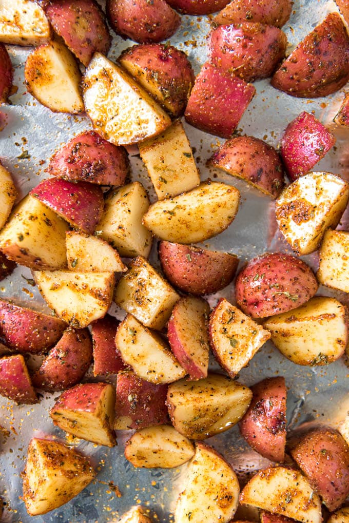 Close up of diced raw red potatoes with olive oil and seasoning