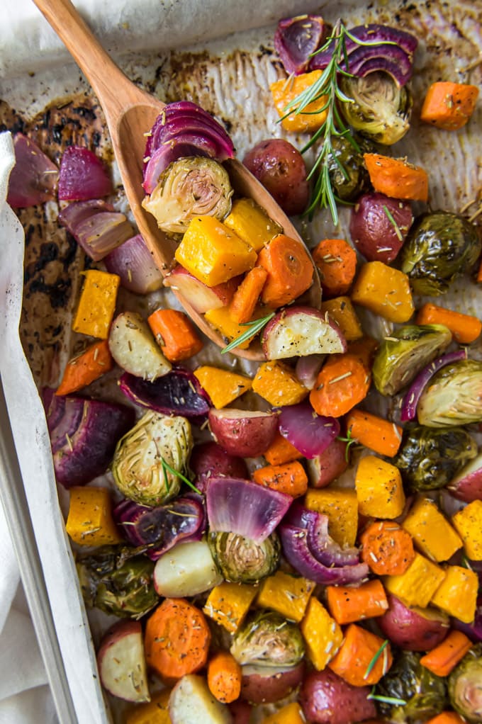 a tray of roasted vegetables with a wooden scoop