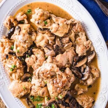 Overhead shot of Instant Pot chicken thighs on brown table.