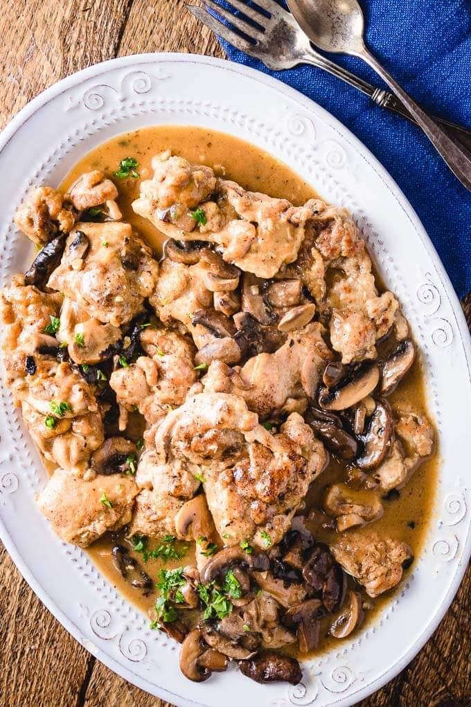 Overhead shot of Instant Pot chicken thighs on brown table.