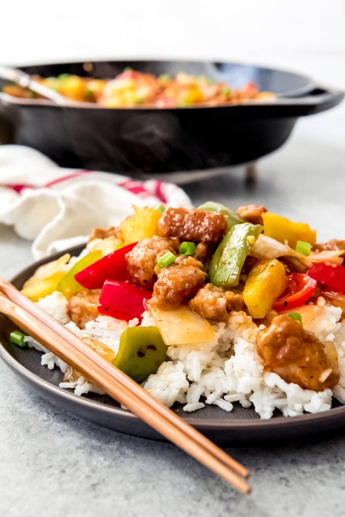 An image of a plate of sweet & sour pork on a bed of white rice.