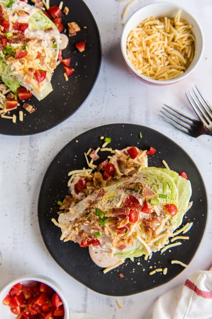 An overhead photo of wedge salads with toppings and dressings.