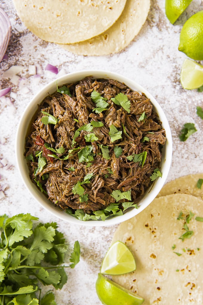 Instant Pot Barbacoa Beef with tortillas, cilantro, and lime