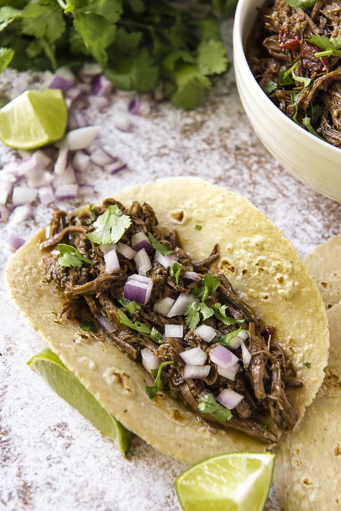 Instant Pot Barbacoa Beef tacos topped with onions and cilantro