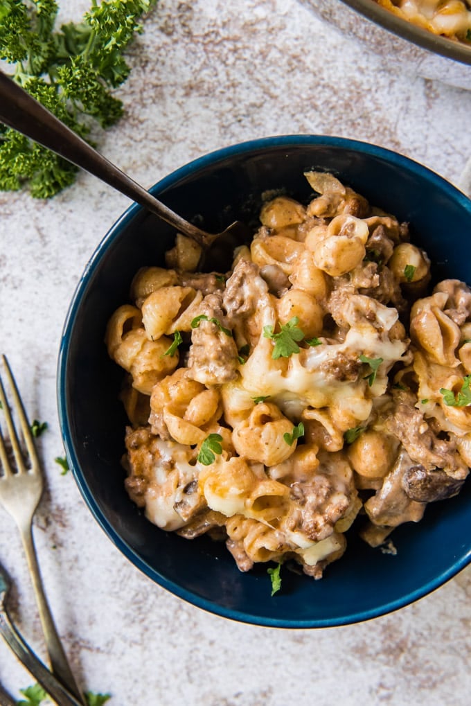 A blue bowl filled with a serving of hamburger casserole