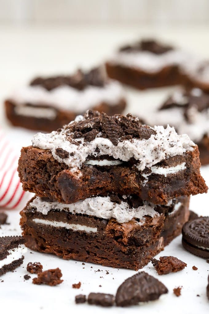 Two Oreo Brownies stacked on top of each other on a piece of parchment paper.
