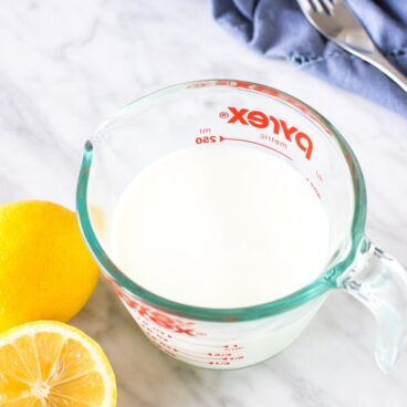 A cup of milk with 2 lemons for making buttermilk