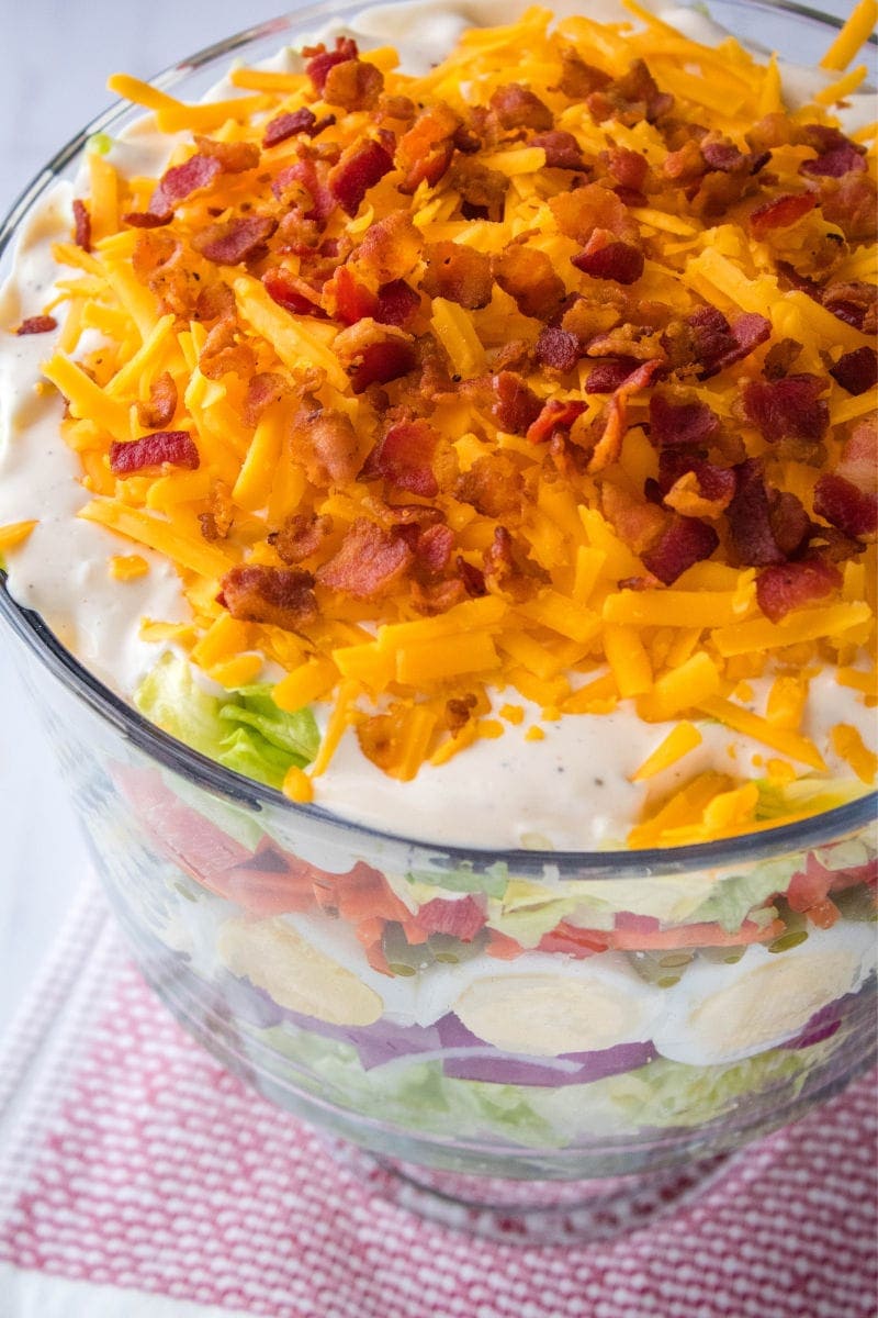 7 layer salad topped with cheese and bacon