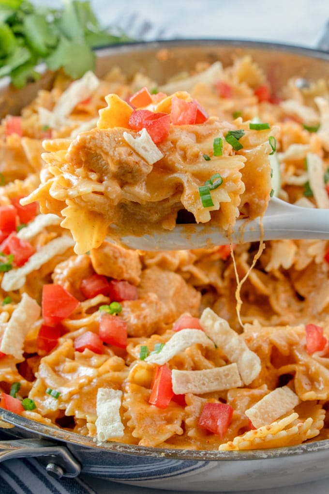 a pot of chicken taco pasta with a serving lifted up by a spoon