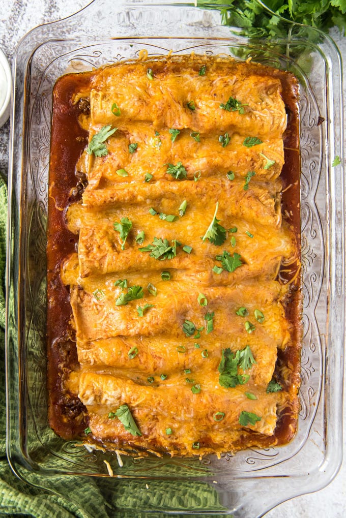 An overhead shot of a pan of baked ground beef enchiladas